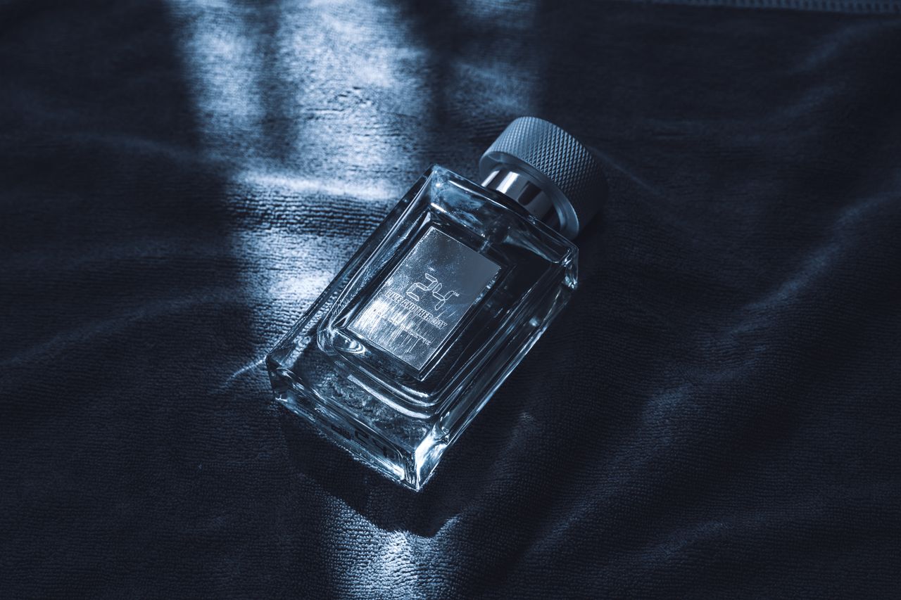 An artistic shot of a luxury perfume bottle resting on textured fabric, emitting sophistication.